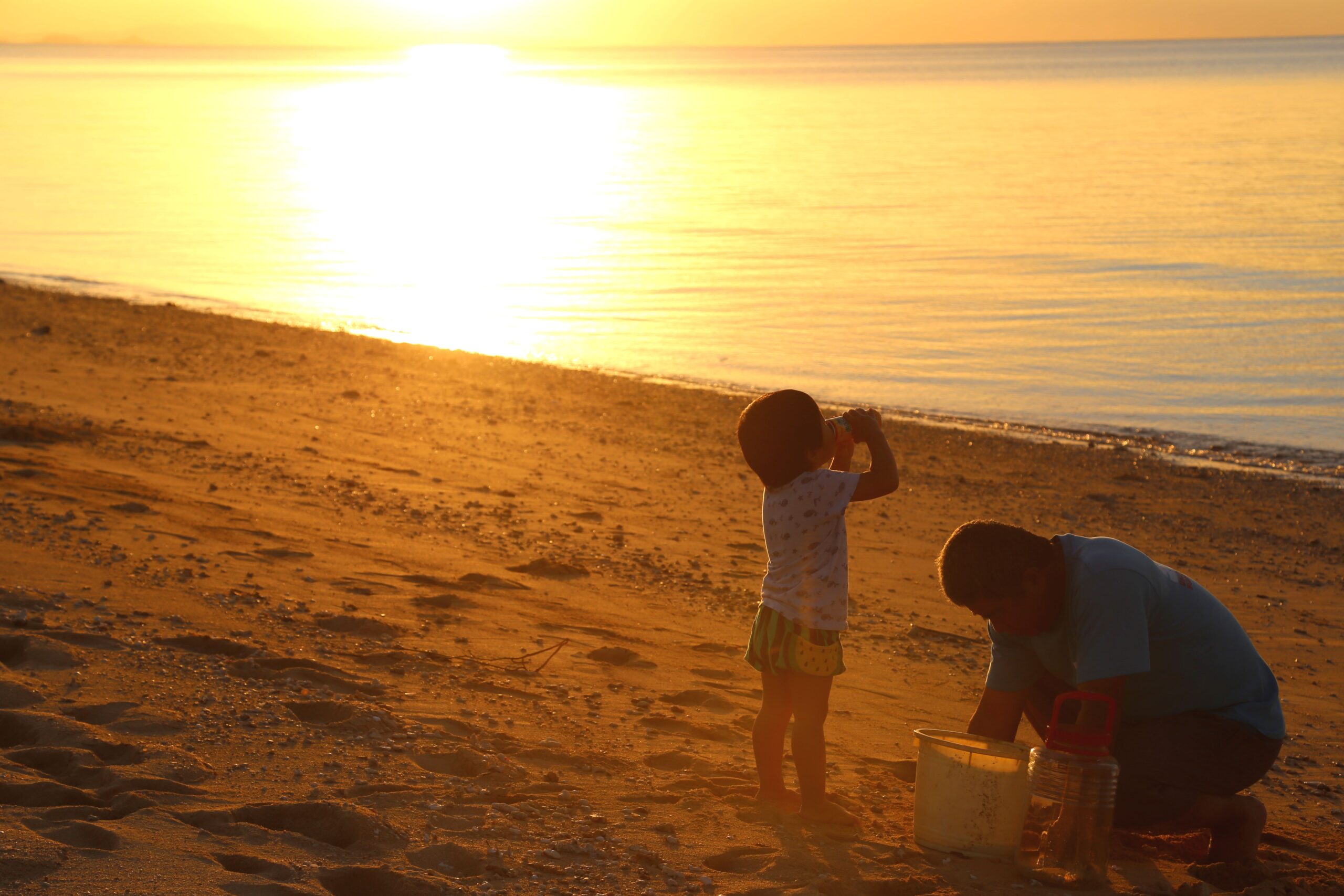 Family enjoying the sunset on Ishigaki Island beach — a peaceful scene before a stargazing tour at Nagareboshi Hill
