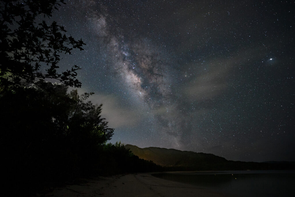 Milky Way over beach with mountains at Ishigaki Island, near Nagareboshi no Oka stargazing spot