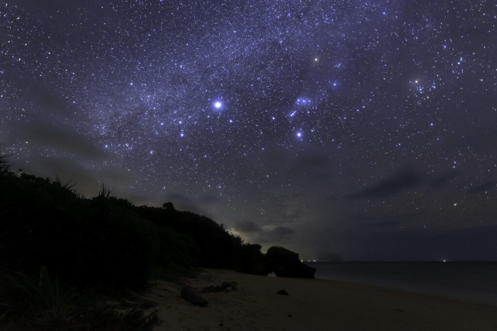 November night sky with Orion constellation over rocky coastline at Ishigaki Island, near Nagareboshi no Oka