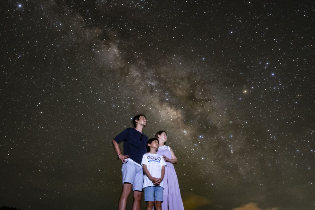 Family with children looking up at the Milky Way at Nagareboshi no Oka stargazing tour, Ishigaki Island
