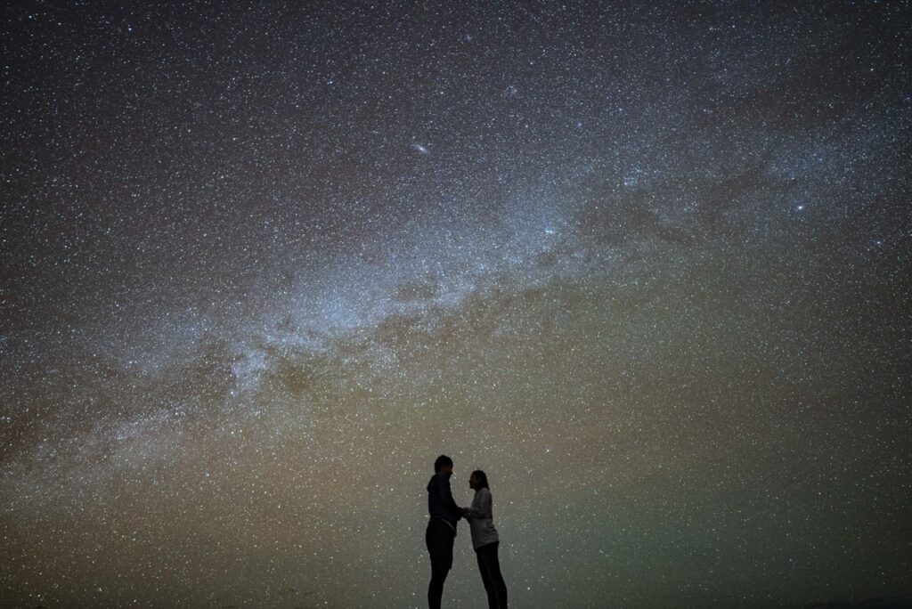 石垣島流れ星の丘で天の川を眺めるカップルのシルエット