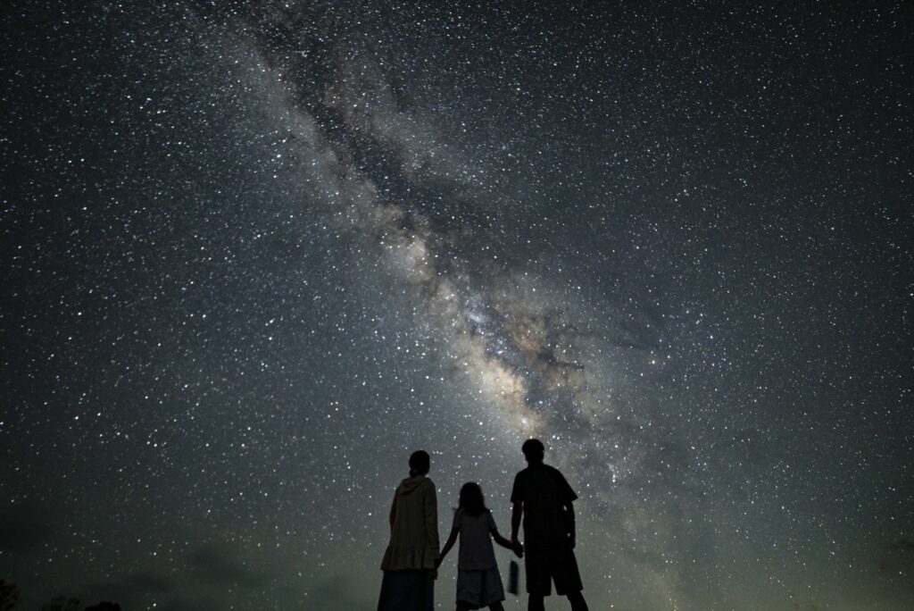 Parent child three silhouette milky way at Nagareboshi no Oka stargazing spot, Ishigaki Island