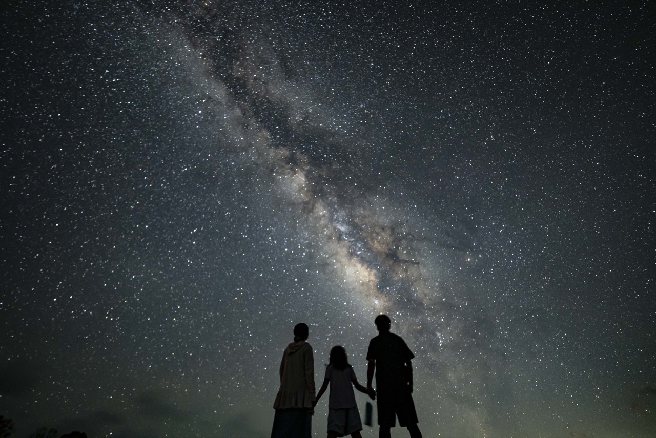 Parent child three silhouette milky way at Nagareboshi no Oka stargazing spot, Ishigaki Island